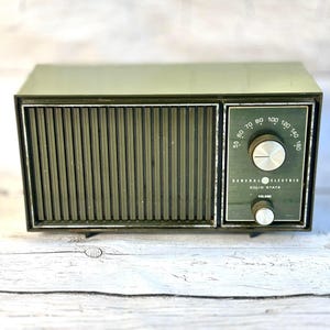 Radio vintage General Electric AM de estado sólido, estilo retro de mediados de siglo, pieza de colección electrónica antigua y funcional.