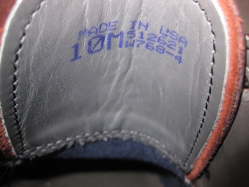 May include: Close-up of the inside of a shoe with a blue label that reads "Made in USA 10M W768-4".