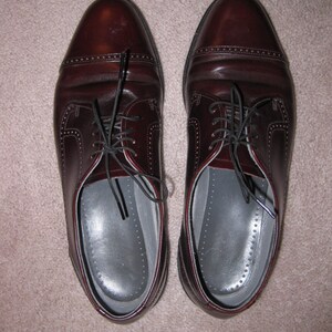 May include: A pair of brown leather lace-up shoes with a classic design. The shoes have a polished finish and are made of high-quality leather.