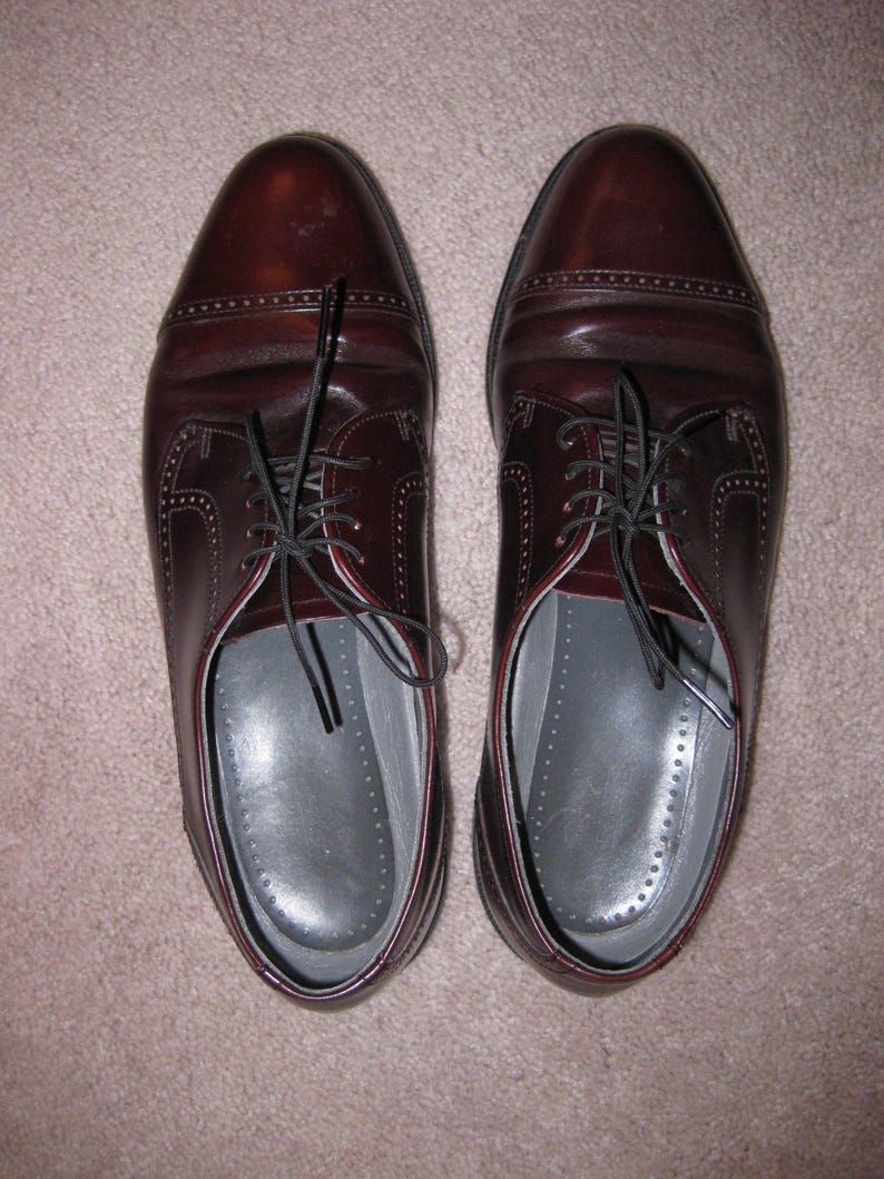 May include: A pair of brown leather lace-up shoes with a classic design. The shoes have a polished finish and are made of high-quality leather.