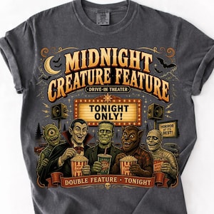 Puede incluir: Una camiseta gris carbón con un estampado gráfico que incluye el texto MIDNIGHT CREATURE FEATURE DRIVE-IN THEATER TONIGHT ONLY! y DOUBLE FEATURE TONIGHT. El diseño muestra a cinco monstruos de cine clásicos sosteniendo palomitas y refrescos.