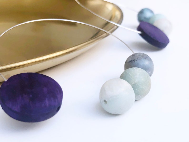 May include: A necklace with a silver chain and a variety of round and oval beads in shades of green, blue, and purple.