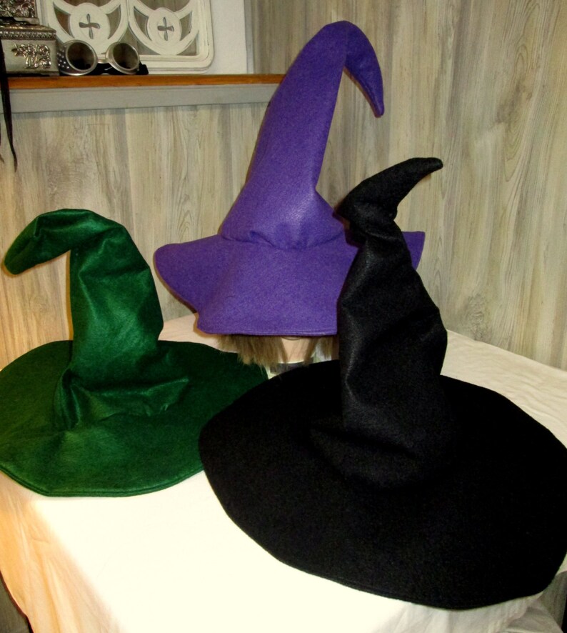 Pu&ograve; includere: Tre cappelli da strega di diversi colori: verde, viola e nero. I cappelli sono fatti di feltro e hanno una corona alta e appuntita.