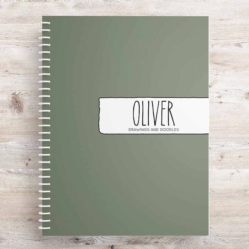 May include: A green spiral bound notebook with a white label that says "Oliver Drawings and Doodles".