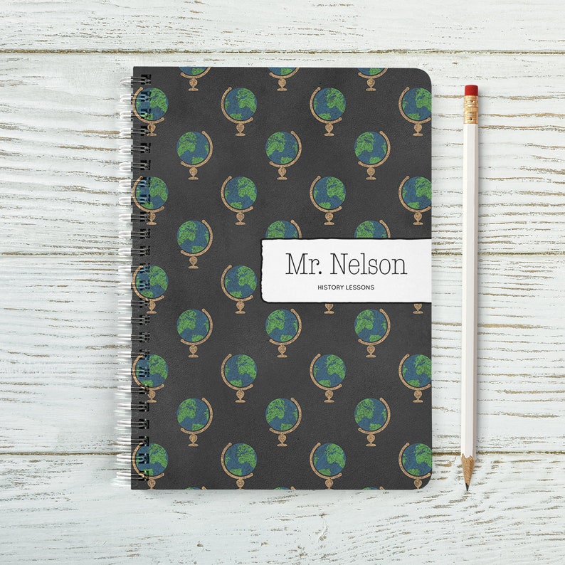 May include: A black spiral notebook with a repeating pattern of globes on the cover. The notebook has a label that says "Mr. Nelson History Lessons".