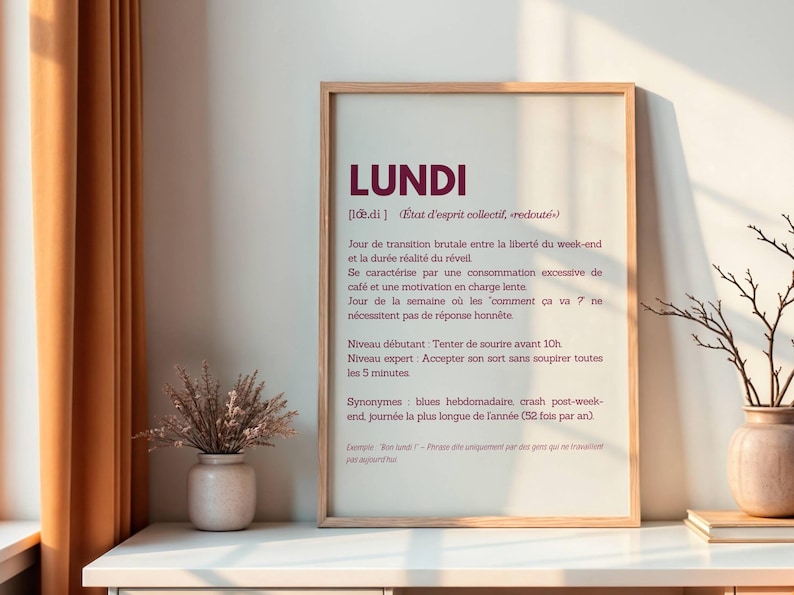 May include: A framed print with a white background and a burgundy text overlay. The text reads "LUNDI" in a large font, followed by a definition of the word in French. The definition includes the word "LUNDI" and describes the day as a "collective state of mind, dreaded".