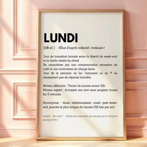 May include: A printable wall art poster with a gold frame. The poster features a definition of the French word "Lundi" (Monday) in black text on a white background. The definition describes Monday as a day of transition from the weekend to the work week, characterized by excessive coffee consumption and low motivation.