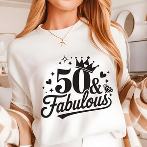 May include: White sweatshirt with a black graphic design that says "50 & Fabulous" with a crown and a diamond.