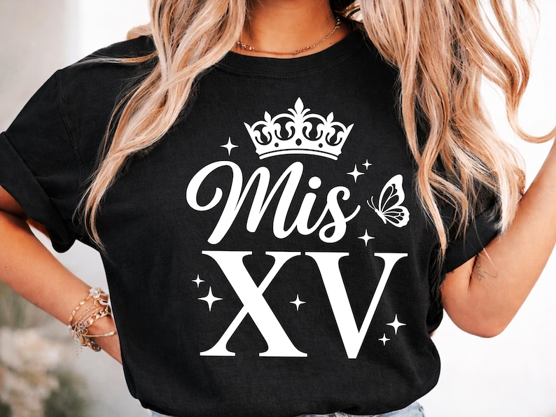 May include: Black t-shirt with the text "Mis XV" in white script, a crown, a butterfly, and the Roman numerals XV. The design includes star accents.
