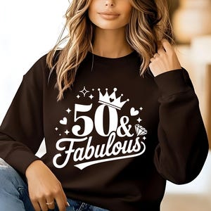 May include: A black sweatshirt with a white graphic design that says "50 & Fabulous" with a crown and a diamond.