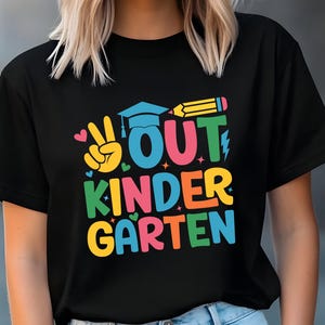 May include: Black t-shirt with a colorful graphic that says "OUT KINDERGARTEN" with a peace sign, a graduation cap, and a pencil.
