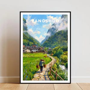 以下が含まれることがあります： 中国の陽朔の風景を描いた額装アートプリント。円錐形の帽子をかぶった人物が、天秤棒で2つの籠を担いで石畳の道を歩いており、周囲には緑の稲田、山々、小川が描かれています。上部には「YANGSHUO CHINA」の文字があります。