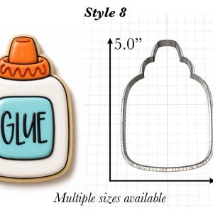Op de afbeelding: Een koekje in de vorm van een lijmfles met wit glazuur, een lichtblauw label in het midden met het woord GLUE in het zwart en een oranje dop. Daarnaast staat een metalen uitsteekvorm op een raster, 12,7 cm hoog en 8,6 cm breed.
