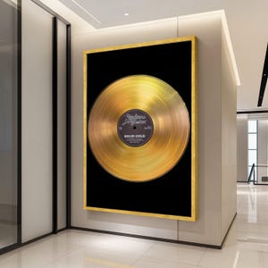May include: A framed gold record against a black backdrop. The record's label reads "Hallans & Butter" and "SOLID GOLD". The gold frame surrounds the artwork, which is displayed on a wall in a bright hallway.