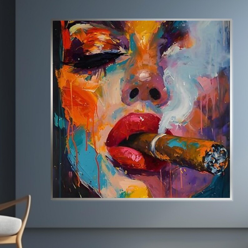 May include: Abstract painting of a face with closed eyes and red lips smoking a cigar. The artwork features a vibrant color palette of orange, blue, purple, and white, with visible brushstrokes and paint drips. The painting is framed in a silver border.