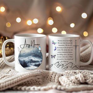 Op de afbeelding: Witte keramische mok met een wikkelontwerp. Eén kant heeft een winterlandschap met een kasteel en de tekst "Any Name". De andere kant heeft een citaat, vlinders, een zwaard en bergillustraties.