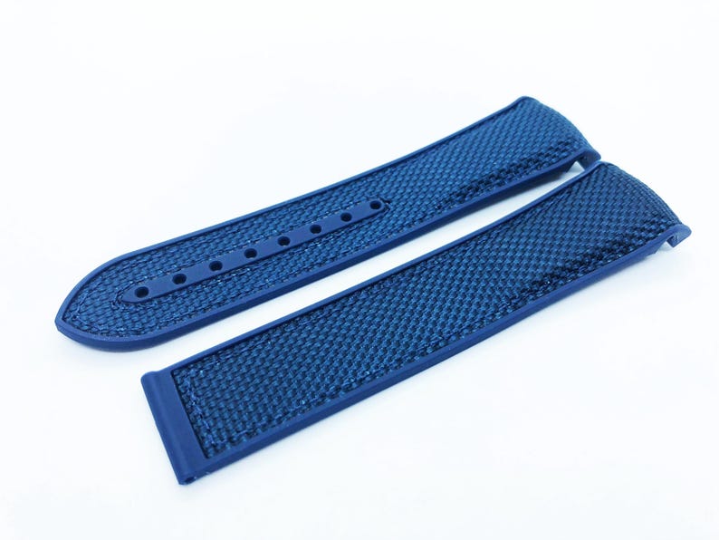 May include: A pair of new, blue watch straps. The straps are made of a textured material with a grid pattern. One strap has several holes for adjustment, and the other has a buckle. The straps are a deep, solid blue color.