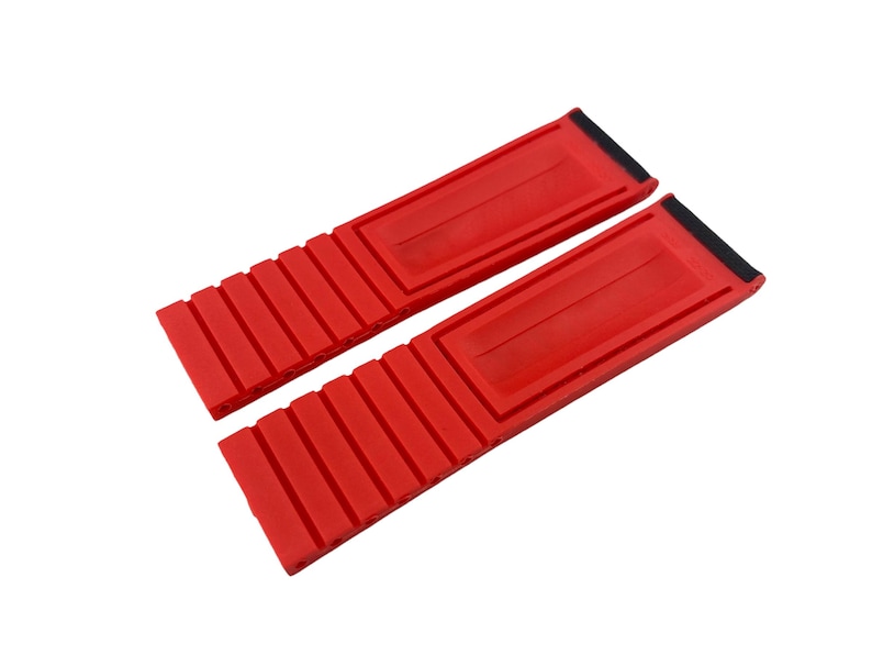 May include: Two red silicone watch straps with a ribbed texture. The straps are designed to fit a watch with a 22mm lug width.