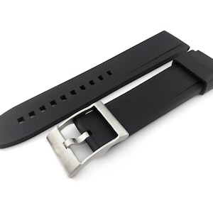 May include: A black silicone watch strap with a silver buckle. The strap has a textured surface and is designed for a watch with a 22mm lug width.