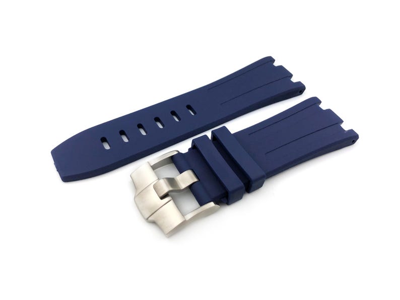 May include: A dark blue silicone watch strap with a silver buckle. The strap has a textured surface and is designed for a watch with a lug width of 22mm.