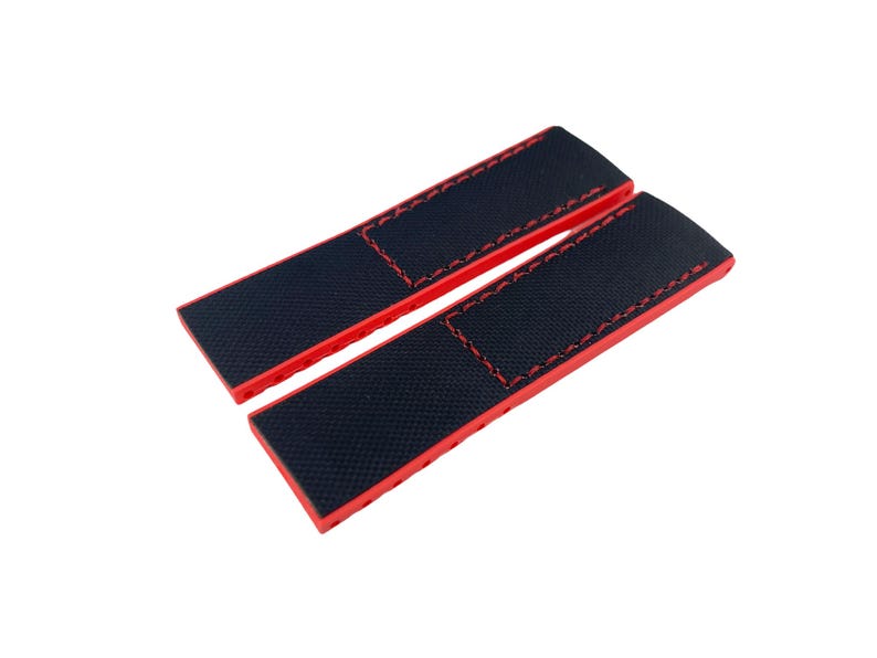 May include: Two red watch straps with black fabric inserts and red stitching.