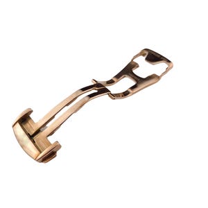 May include: A rose gold watch clasp, featuring a curved design with a hinged mechanism. The clasp is made of a shiny, metallic material and is designed to secure a watch band. The overall shape is elongated and slightly curved.