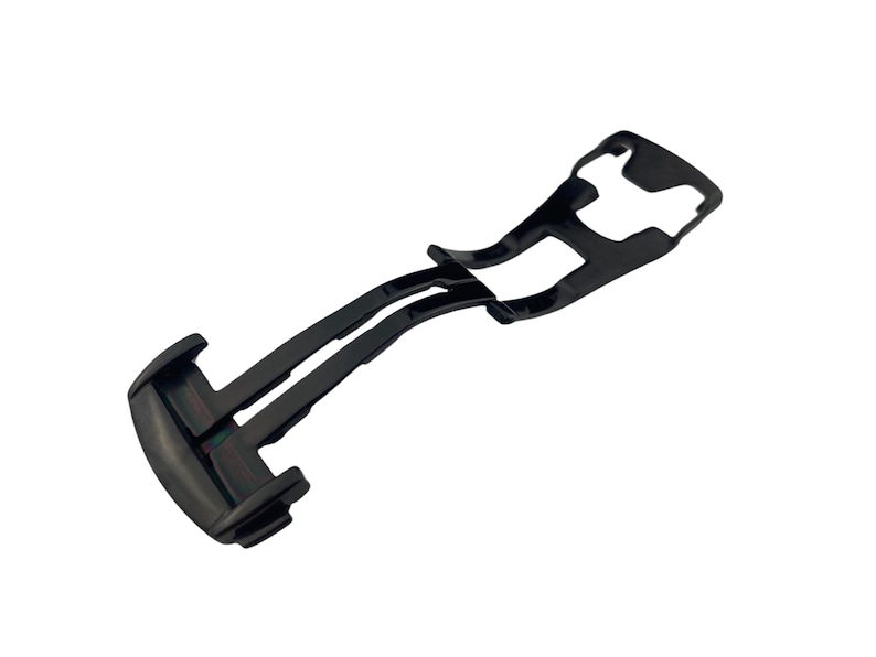 May include: A black watch clasp, a component of a watch band, is displayed against a white background. The clasp is made of a dark, possibly metal, material and features a hinged design for secure fastening. The design is sleek and modern.