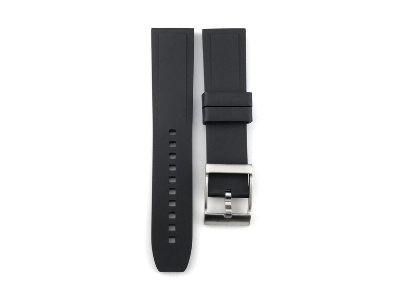 May include: Black rubber watch strap with a silver buckle.