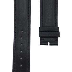 Puede incluir: Una correa de reloj de cuero negro con detalles de costura. La correa tiene un extremo puntiagudo y una hebilla.