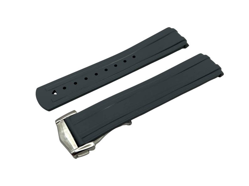 May include: A dark gray watch strap with a silver-colored clasp. The strap is made of a flexible material and has a series of holes for adjustment. The watch strap is designed to be durable and comfortable for everyday wear.