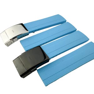 Puede incluir: Cuatro correas de reloj azules con hebillas plateadas y negras. Las hebillas tienen la palabra "Isofrane" impresa.
