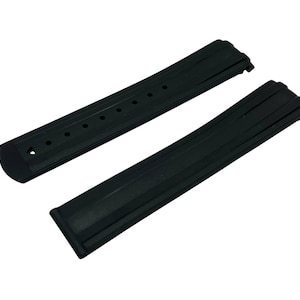 May include: Two black watch straps. One strap has several holes for adjustment. The other strap has a ridged design. Both straps are made of a flexible material and are designed to attach to a watch face.