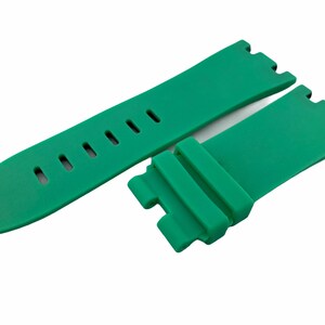 May include: A green silicone watch strap with a buckle and holes for adjusting the size.