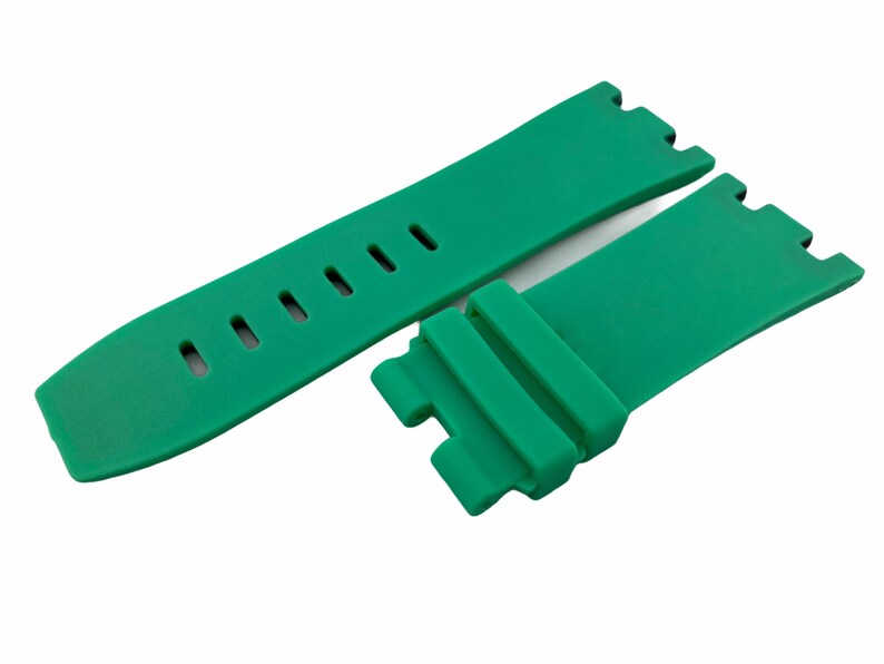 May include: A green silicone watch strap with a buckle and holes for adjusting the size.
