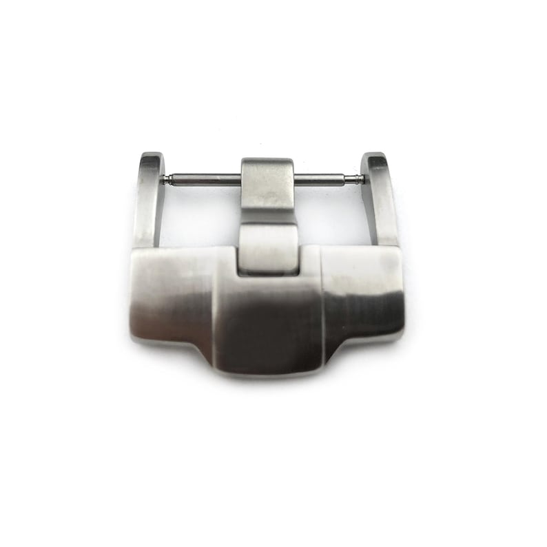 May include: A silver metal watch band buckle with a polished finish.