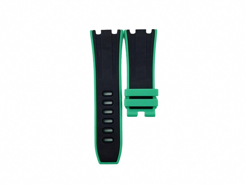 May include: Black and green watch strap with a buckle. The strap has a textured surface and multiple holes for adjusting the fit.