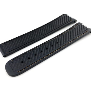 May include: Two black rubber watch straps with a textured pattern and orange stitching.