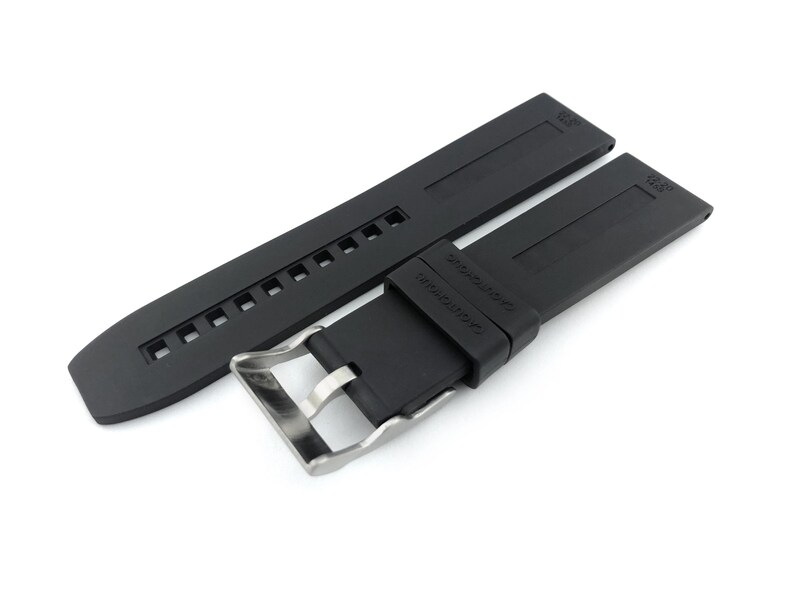 May include: Black rubber watch strap with a stainless steel buckle. The strap has a textured surface and is designed for a watch with 22mm lugs.
