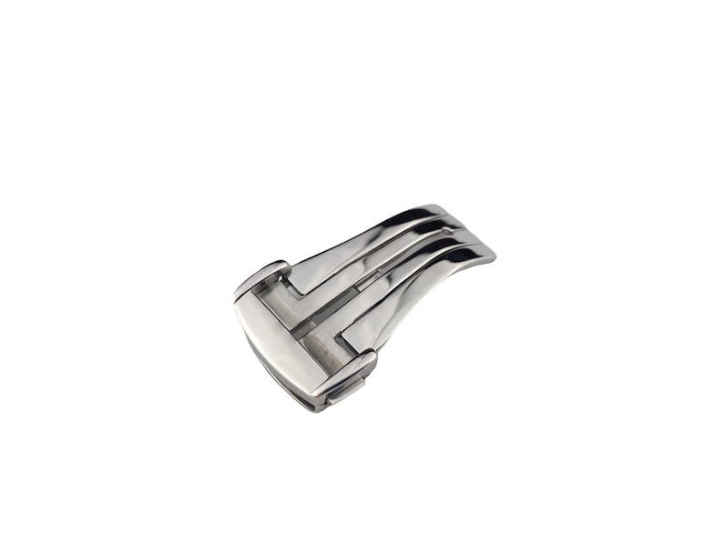 May include: A silver-colored watch clasp with a curved design. The clasp has a rectangular shape with a series of parallel bars and a hinged section. The metal has a polished, reflective surface.