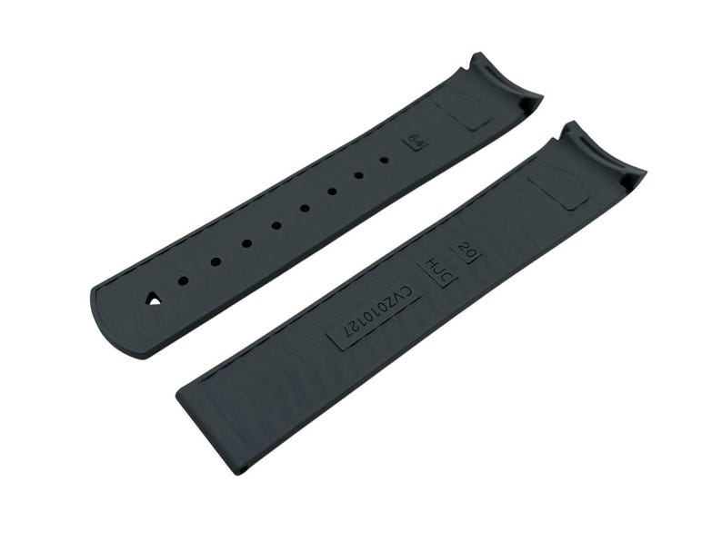 May include: Two-piece dark gray watch strap. The strap has a curved design to fit the watch case. One piece has holes for adjustment, the other has the text "20" and "HJC" and the code "CV2010127".