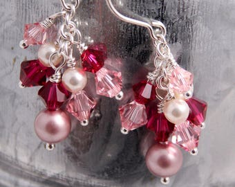 Peut inclure: Une paire de boucles d'oreilles pendantes avec des perles de cristal roses et rouges et des perles. Les boucles d'oreilles sont en argent et ont un design délicat et féminin.