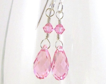 May include: A pair of silver dangle earrings with pink crystal teardrop shaped drops.