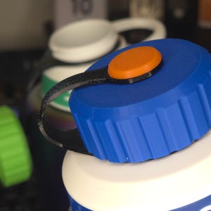 May include: A blue and white water bottle with a blue lid and an orange button. The bottle has a textured blue band around the bottom and the word "Circl" printed on the side.
