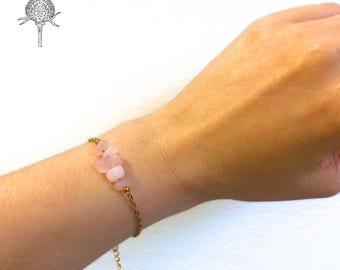Könnte beinhalten: Ein zartes Armband aus einer goldenen Kette mit einem Cluster aus hellrosa Rosenquarzsteinen.