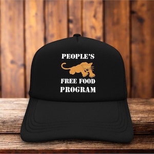 Peut inclure: Casquette de camionneur noire avec une visière incurvée. Le texte "PEOPLE'S FREE FOOD PROGRAM" est en blanc, accompagné d'un dessin de lion orange. Le chapeau est fait d'un tissu résistant et a un dos en filet.