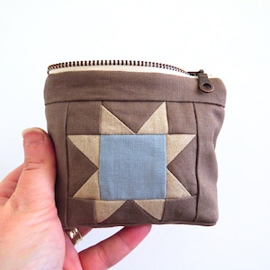 May include: A white ceramic mug with a black handle and the text "But First, Coffee" in a black, bold font. The mug is on a white surface. The mug is approximately 10 cm tall.