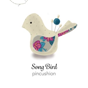 Può includere: Un cuscino per spilli a forma di uccello beige con un motivo floreale sul davanti. Il cuscino ha un piccolo occhio nero ed è pieno di spilli. Il testo "Song Bird pincushion" è scritto sotto il cuscino.