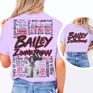 May include: A light purple t-shirt featuring a large graphic on the back with the text Bailey Zimmerman, song titles, and a portrait of a person in a denim jacket. The front of the shirt displays the text Bailey Zimmerman in black and red.