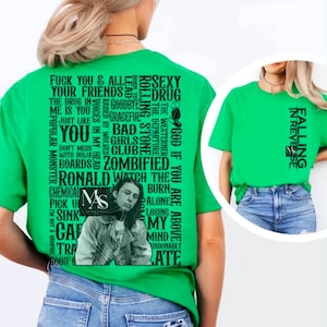 以下が含まれることがあります： 鮮やかなグリーンのTシャツ。背面には「Sexy Drug」、「Bad Girls Club」、「Zombified」などのフレーズを含むテキストのコラージュと、人物のモノクロポートレートが大きくプリントされています。前面には「Falling in Reverse」のテキストがあります。