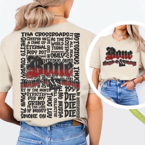 May include: A beige t-shirt featuring a large black text graphic on the back listing song titles and phrases including Bone, Tha Crossroads, and 1st of the Month. The front chest displays the word Bone in red and black with a small logo.